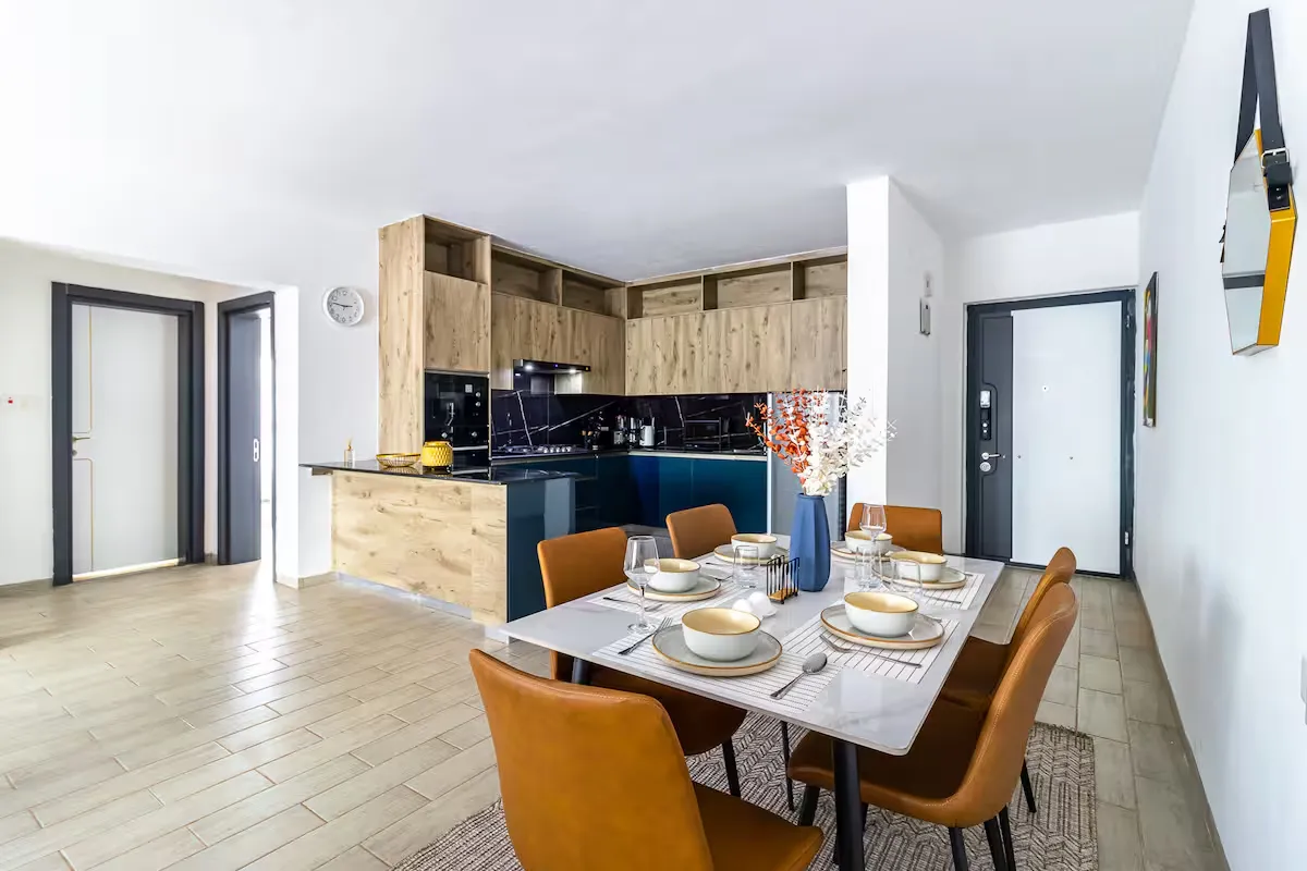 Open-plan kitchen and dining area with wooden cabinets and a set table